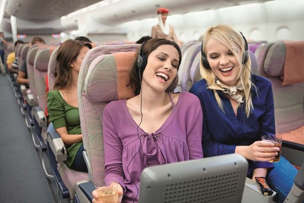 Люди сидят в самолете. Самолет с пассажиром. Салон самолета с пассажирами. Люди в самолете. Две девушки в самолете.